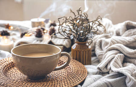 Cozy autumn composition with a big cup of coffee in bed.の写真素材