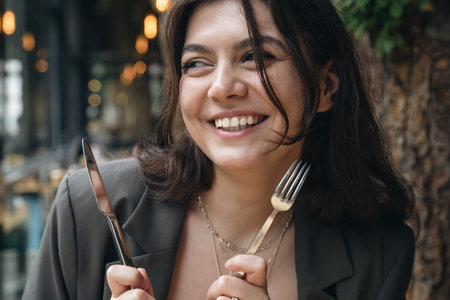 Attractive young woman with cutlery in a restaurant.の写真素材