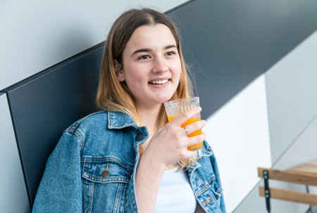 Woman drinks orange juice in a cafe, close-up.