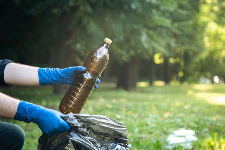 Close-up, a plastic bottle in a male hand, cleaning up nature.の写真素材