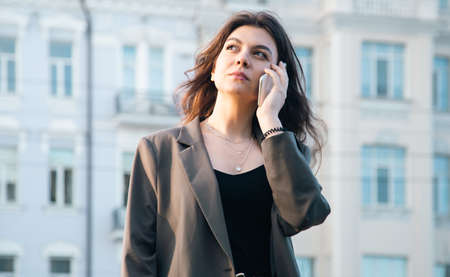 Business young woman with a smartphone on a blurred background of the city.の写真素材