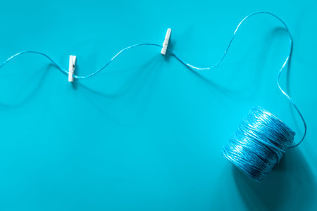 A ball of blue threads on a blue background, flat lay.