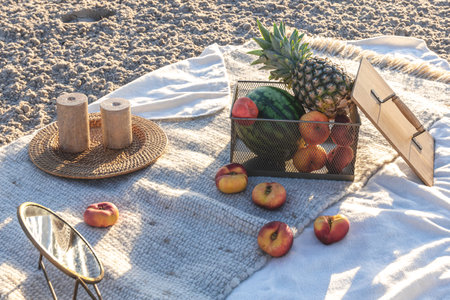 Plaid with fruits on the sandy seashore, picnic by the sea.の写真素材