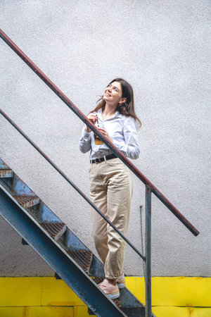 Business young woman near the stairs with a cup of coffee.