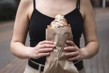 Croissant in a craft paper bag in female hands.の写真素材
