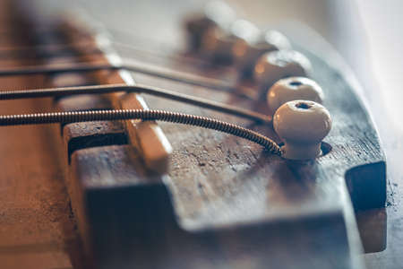Acoustic guitar bridge and strings close up.の写真素材