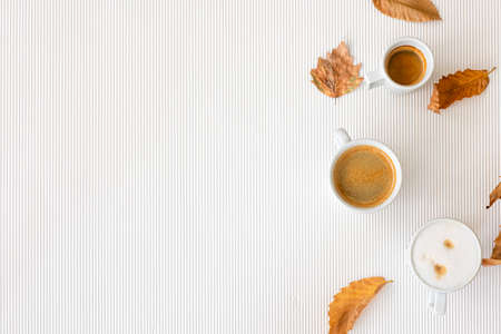 Autumn composition with cups of coffee and leaves on a white background.の写真素材