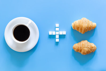 A cup of coffee, a plus sign made of sugar, and a croissants, flat lay.の写真素材