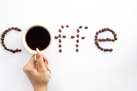 Cup of coffee and coffee beans make the word coffee, flat lay.の写真素材