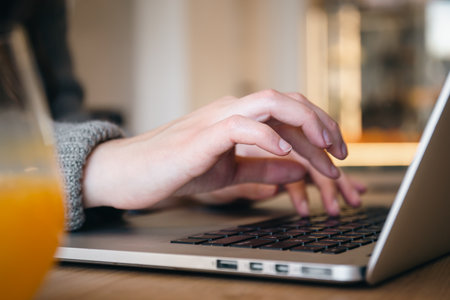 Close-up, female hands are typing on a laptop.の写真素材