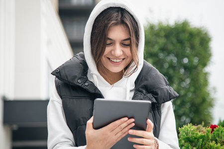 Happy young woman is using a tablet and smiling.の写真素材