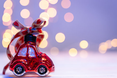 Close-up, car-shaped Christmas toy on a blurred background with bokeh.の写真素材