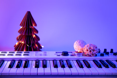 Christmas background with midi keyboard and holiday decor with neon lights.の写真素材