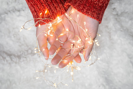 Close-up, tangled garland in female hands, top view.