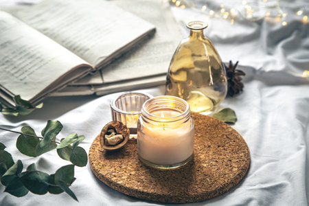 Cozy home composition with candles and books in bed.の写真素材