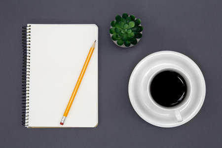 Blank notepad and coffee cup on dark background, conceptual minimalism, copy space.の写真素材