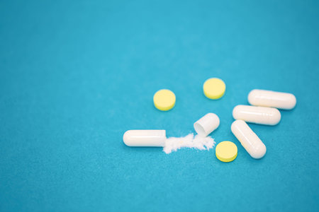 Pills on a blue background, close-up, medicine and health concept, copy space.