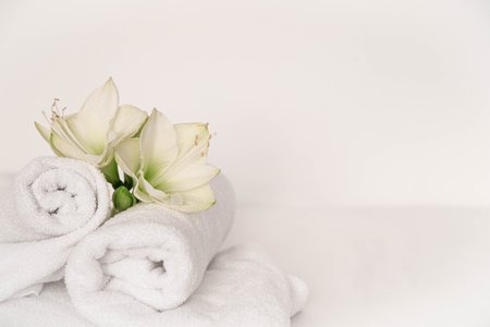 Spa composition with lily flowers and towels on a white background, copy space.の写真素材