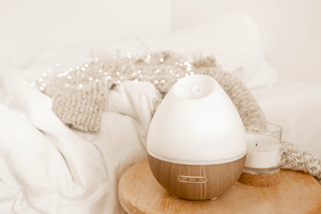A cozy composition with an aroma diffuser and a candle in the interior of the room.の写真素材