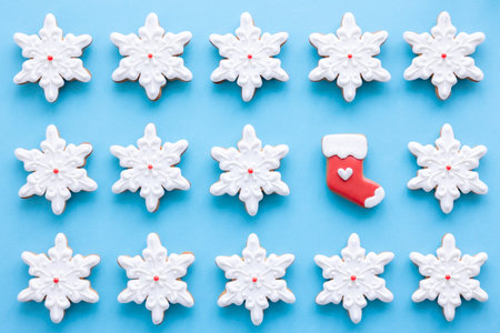 Christmas background with gingerbread in the form of snowflakes covered with icing on a blue...