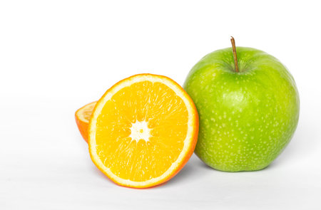Green apple and orange on a white background isolated, copy space.の写真素材
