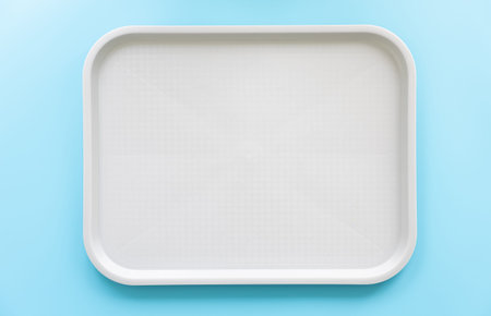 White tray on a blue background, flat lay, copy space.