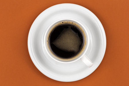 Coffee cup and saucer on brown background, flat lay, close up.の写真素材
