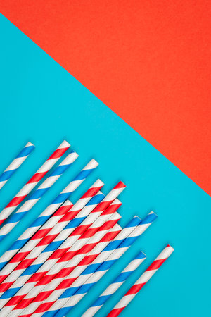 Drinking straws for party on colored background. Top view of colorful paper disposable eco-friendly straws for summer cocktails.の写真素材