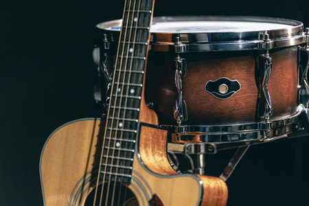 Acoustic guitar and snare drum on a black background isolated.の写真素材