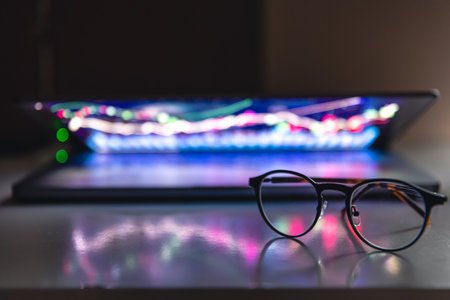 Laptop with graphs and statistics and glasses on the table.の写真素材