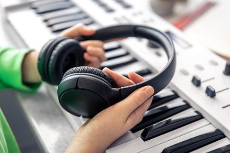 Close-up, black headphones in the hands of a child, music concept.の写真素材