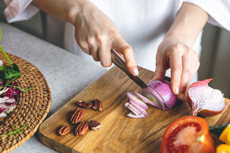 A woman cuts vegetables for a salad, close-up.の写真素材