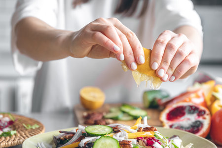 A woman makes a fresh vegetable salad, close-up.の写真素材
