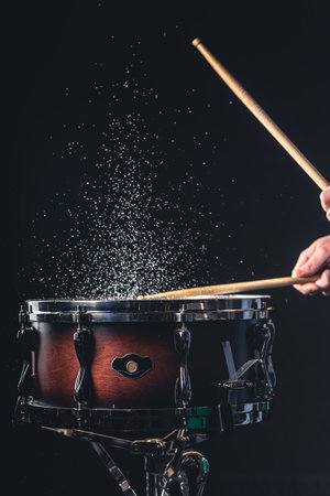 Drummer using drum sticks hitting snare drum with splashing water.の写真素材