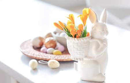Easter still life with a ceramic hare, eggs and flowers.