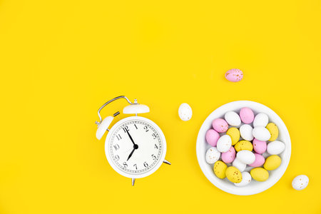 Minimalistic background with alarm clock and steel eggs, flat lay.の写真素材