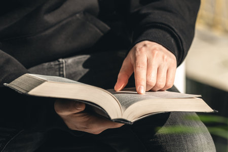 Open book Bible in male hands, close-up.