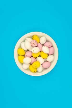 Plate with Easter eggs on a blue background, top view.