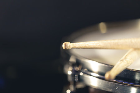 Close-up, snare drum and drumsticks on a dark background.の写真素材