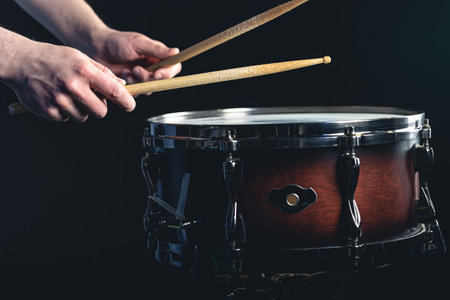 Drummer using drum sticks hitting snare drum with splashing water.の写真素材