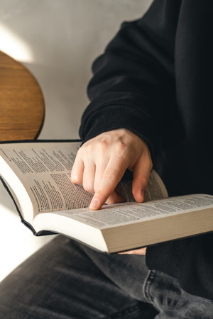 Open book Bible in male hands, close-up.の写真素材
