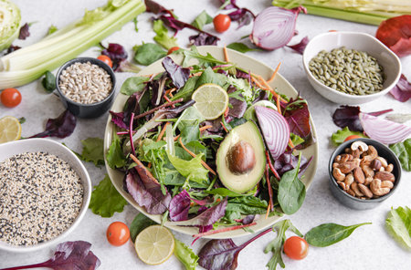 Salad of avocado and vegetables mixed greens lettuce leaves ready to eat.の写真素材