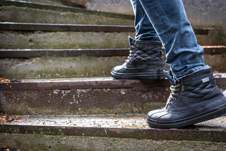 A man in boots on the old steps, close-up.の写真素材