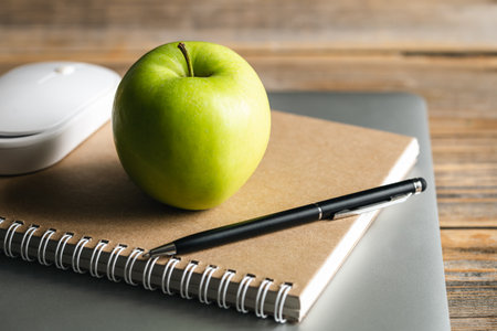 Apple, notepad and laptop on the desktop.の写真素材