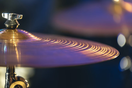 Drum cymbal close-up on a dark blurred background.