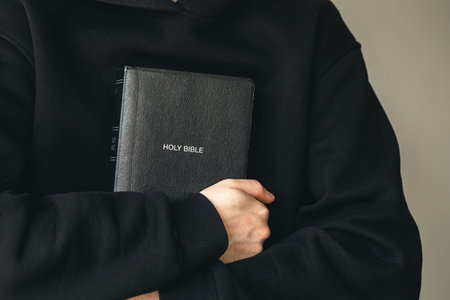 Close-up, holy Bible book in male hands.の写真素材