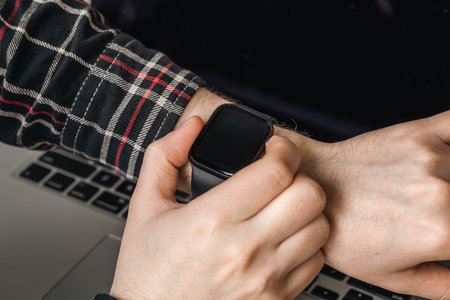 A man uses a smart watch, close-up technology.
