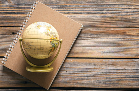 Earth globe and notebook on wooden background, top view.の写真素材