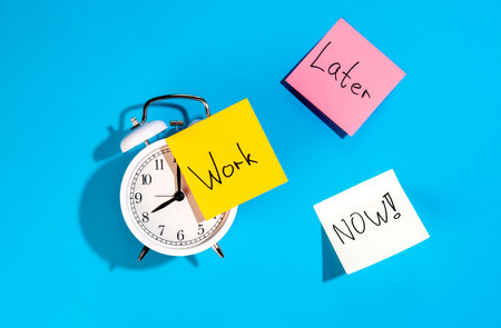 Alarm clock and colorful paper reminders on a blue background, top view.の写真素材