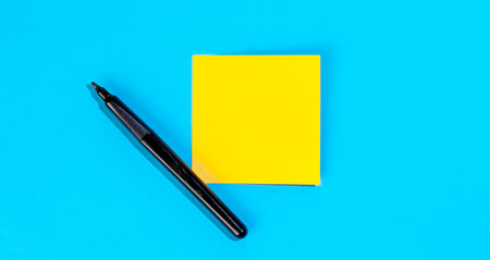 Yellow note with empty place for text with marker on blue background, flat lay.の写真素材